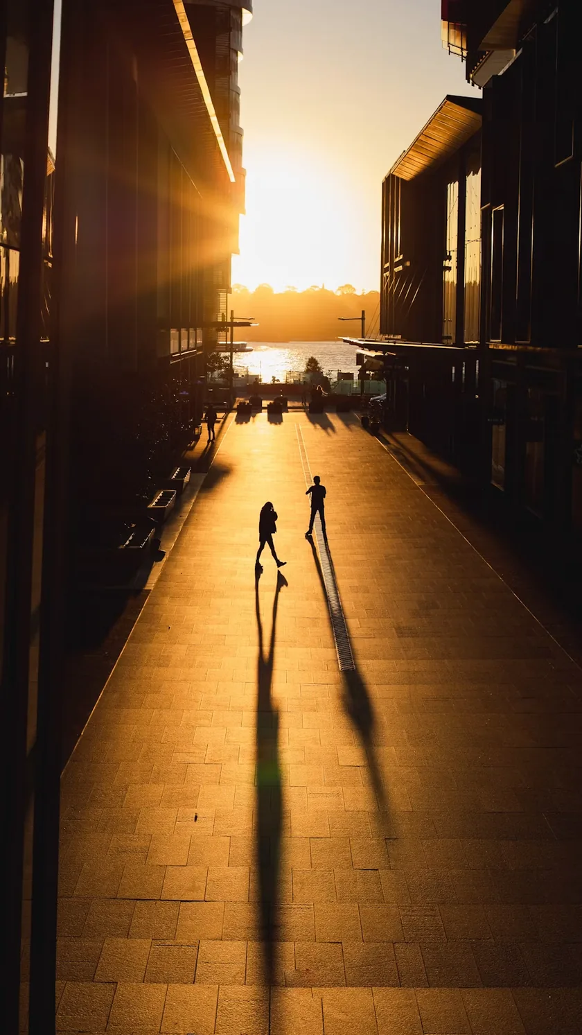 A laneway at sunrise, two long shadows.