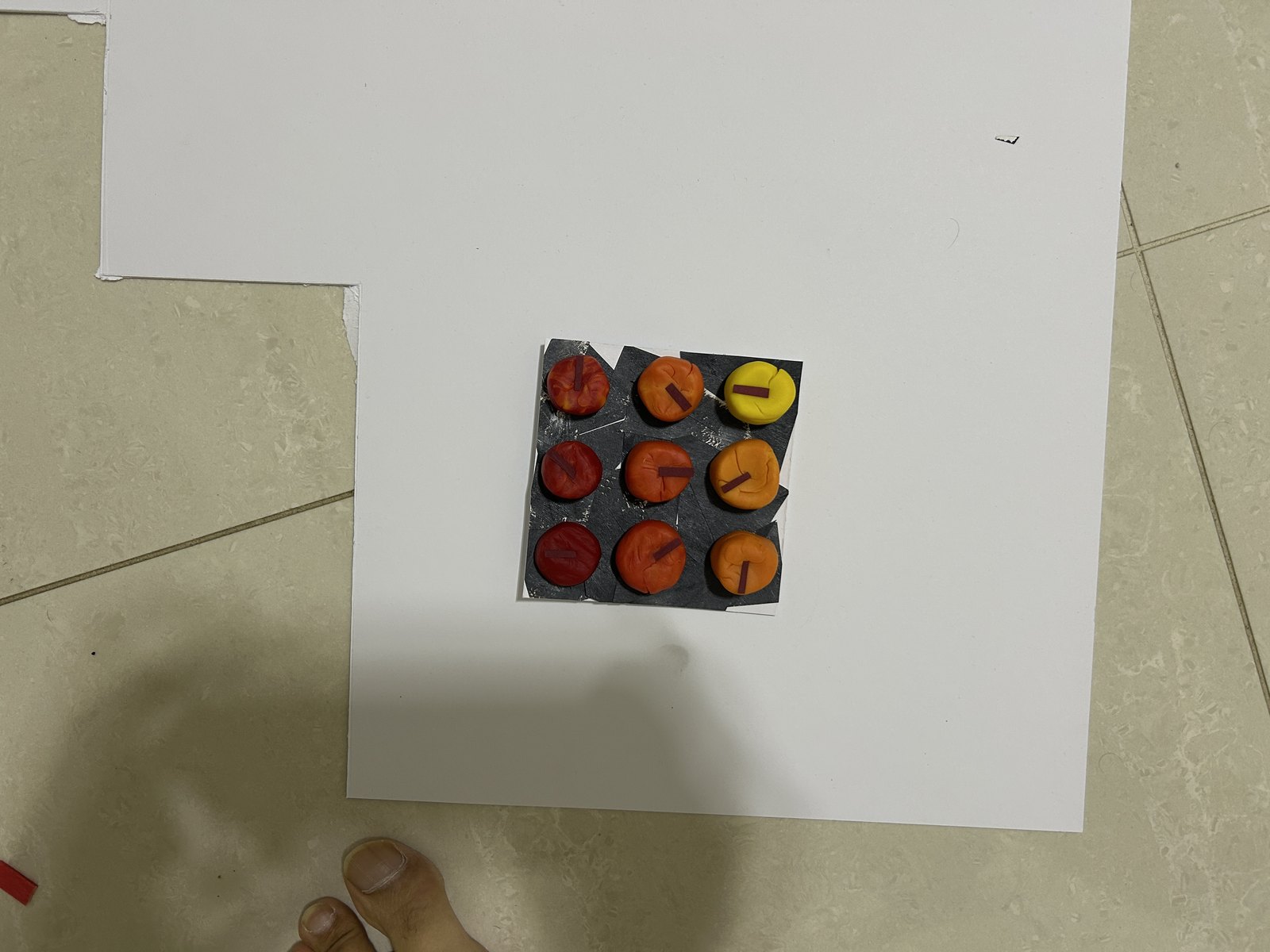 A single tile — nine clay circles with tickers, the repetition study.