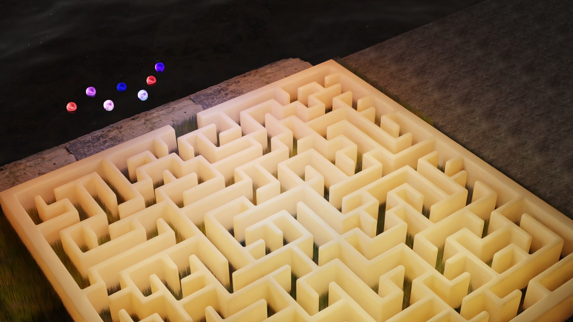 The finished maze, lit, seen from above beside the water.